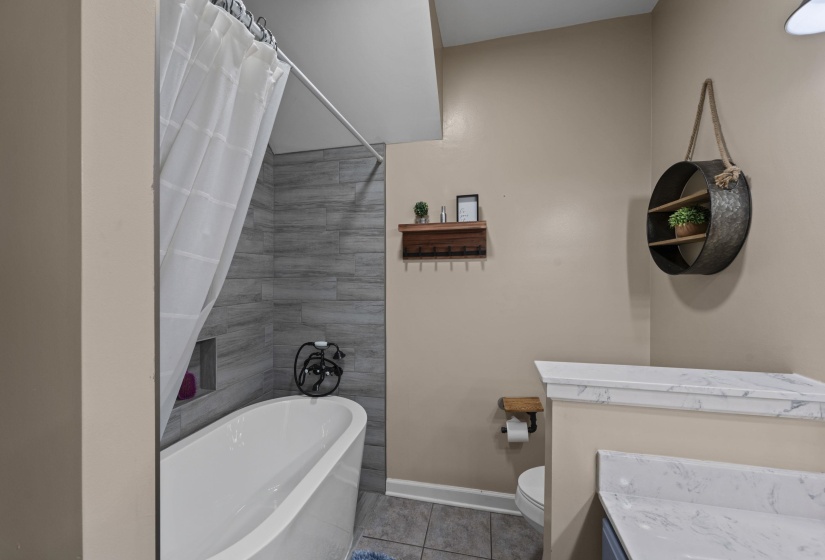 Bathroom with toilet, vanity, tile patterned floors, and baseboards