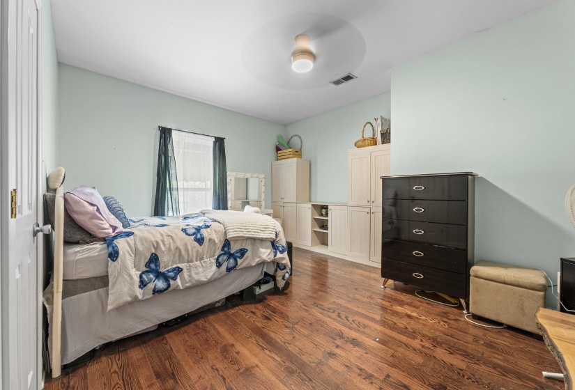 Bedroom featuring wood finished floors, visible vents, and a ceiling fan