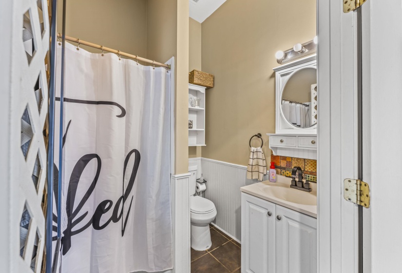 Full bathroom with wainscoting, vanity, toilet, tile patterned flooring, and a shower with shower curtain