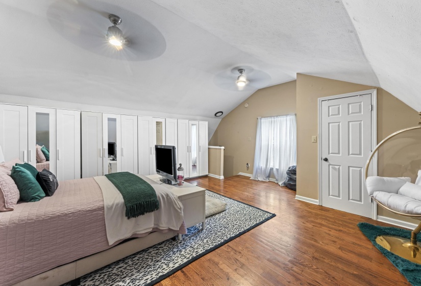 Bedroom featuring ceiling fan, lofted ceiling, wood finished floors, and baseboards