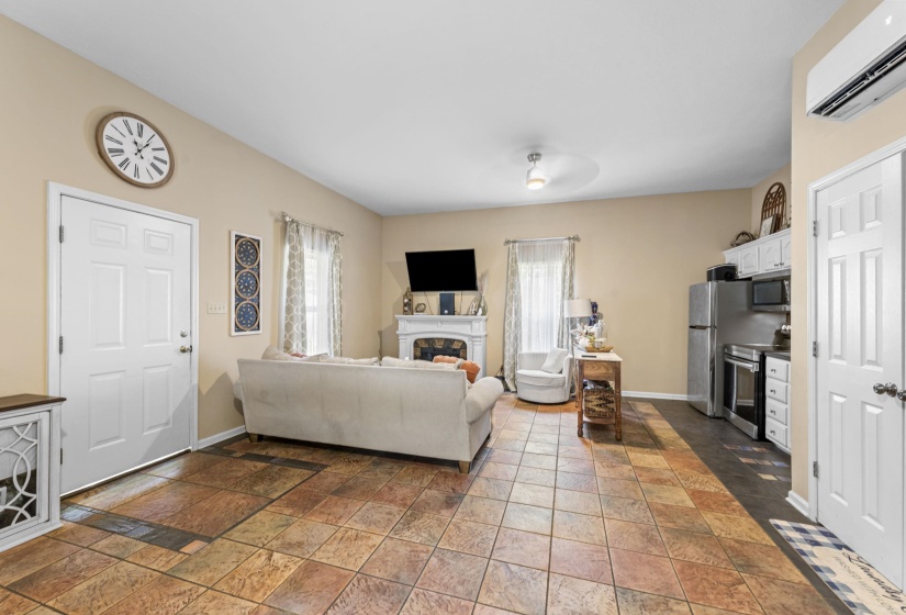 Living room with baseboards, a healthy amount of sunlight, and a wall unit AC