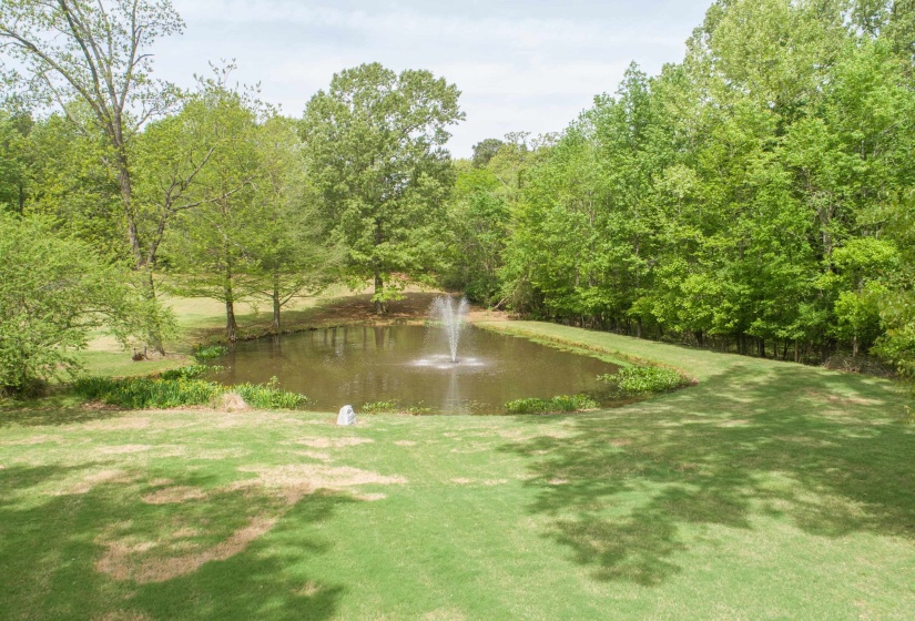 View of property's community with a lawn, a view of trees, and a water view