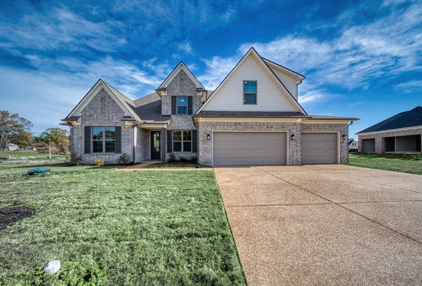 Traditional home with a front lawn, driveway, brick siding, and roof with shingles