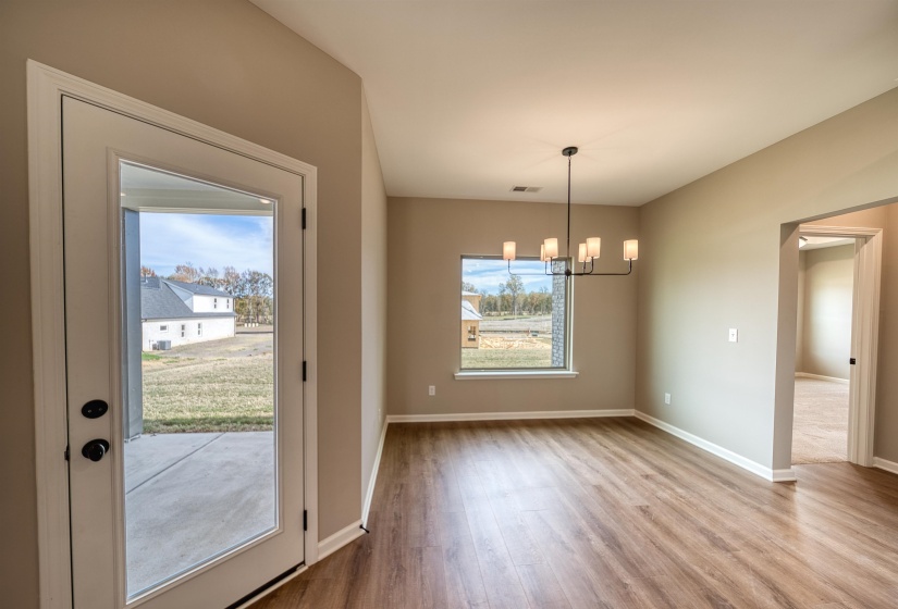 Unfurnished dining area featuring light wood-style flooring and a chandelier