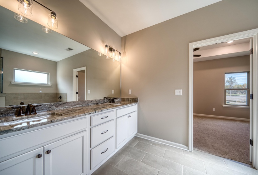 Bathroom featuring plenty of natural light, light tile patterned floors, double vanity, recessed lighting, and light carpet