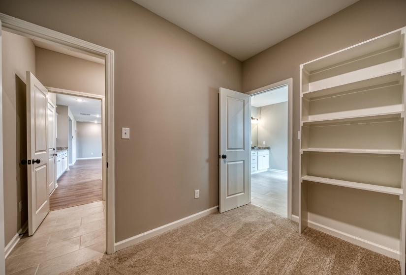 Unfurnished bedroom with light carpet and light tile patterned flooring