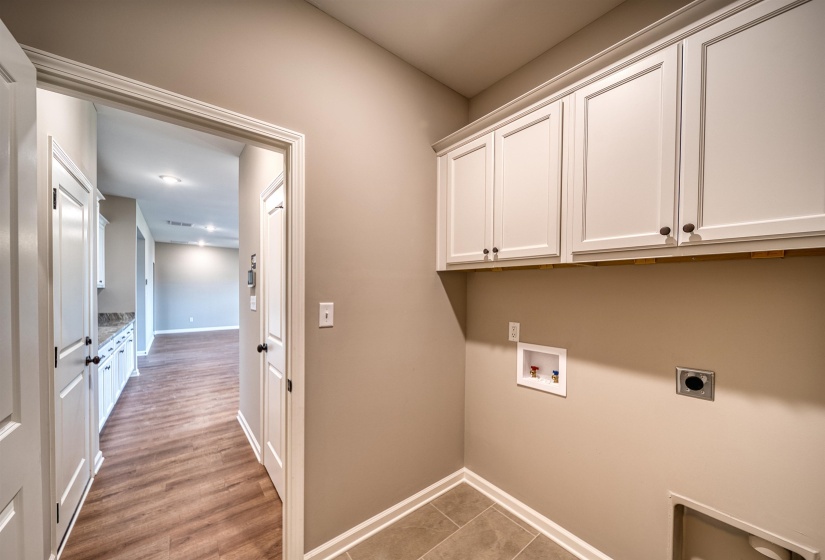 Washroom with cabinet space, hookup for an electric dryer, washer hookup, and light wood-style flooring