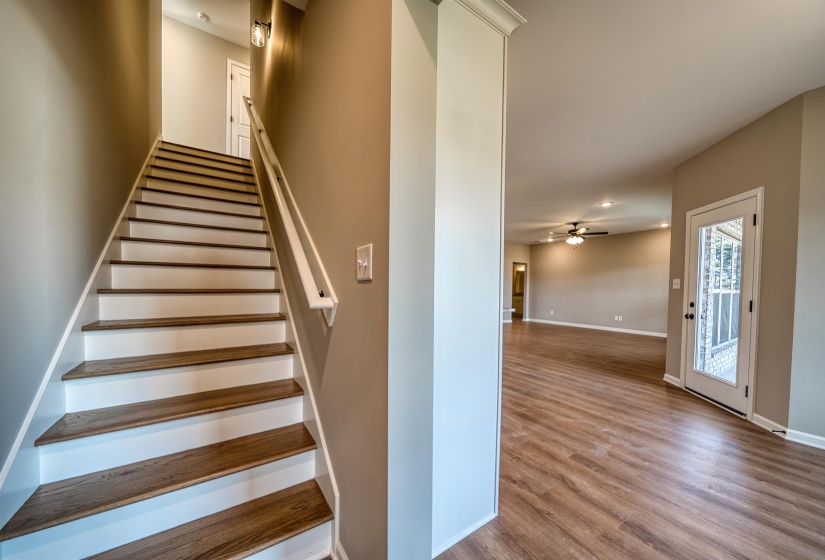 Stairway with wood finished floors and ceiling fan