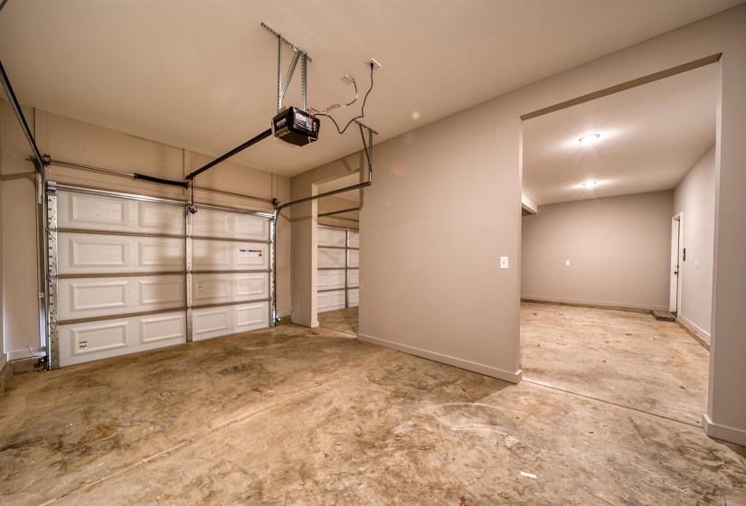 Garage with baseboards and a garage door opener