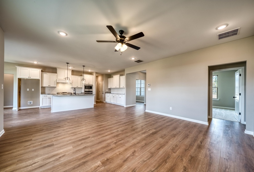 Unfurnished living room with ceiling fan, dark wood-type flooring, recessed lighting, and healthy amount of natural light