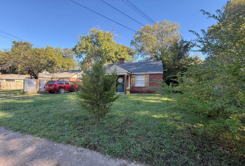 View of front of house with a chimney and brick siding