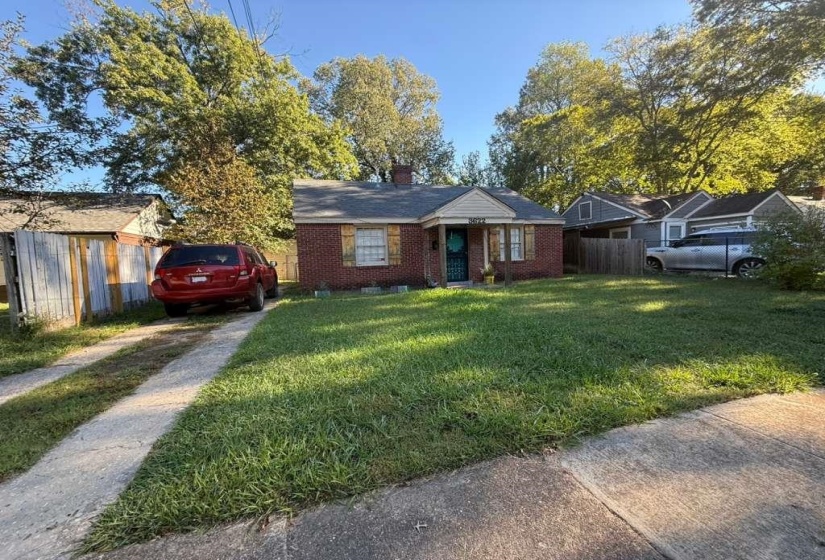 View of front of property with a chimney and brick siding