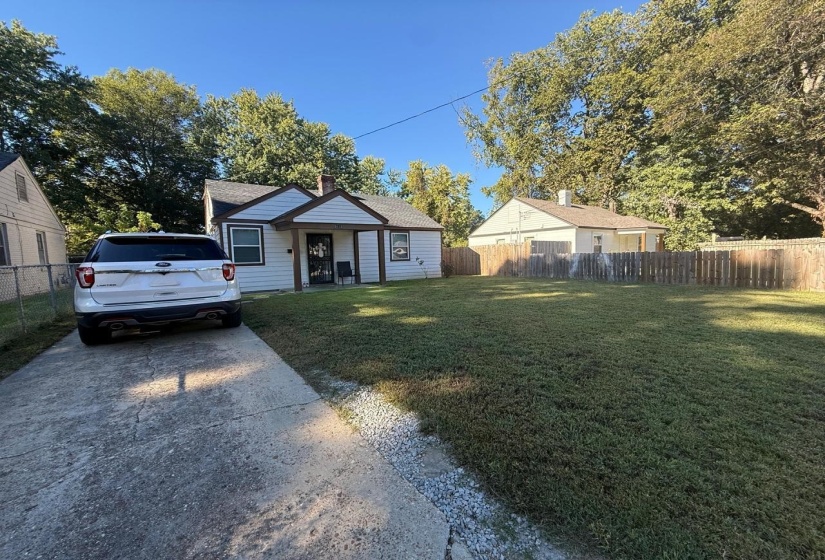 Bungalow featuring driveway, a chimney, and roof with shingles