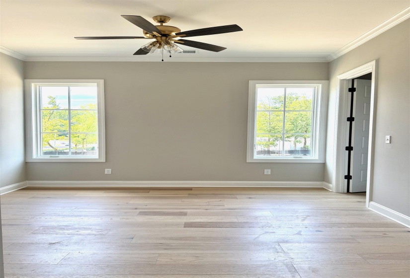 Bedroom featuring crown molding, light wood-type flooring, and a ceiling fan