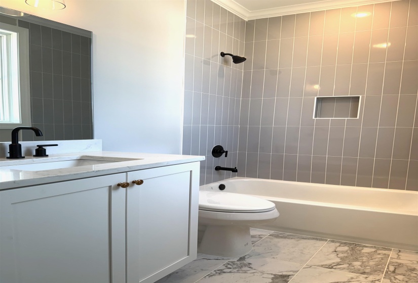 Bathroom featuring vanity, bathing tub / shower combination, and light marble finish floors