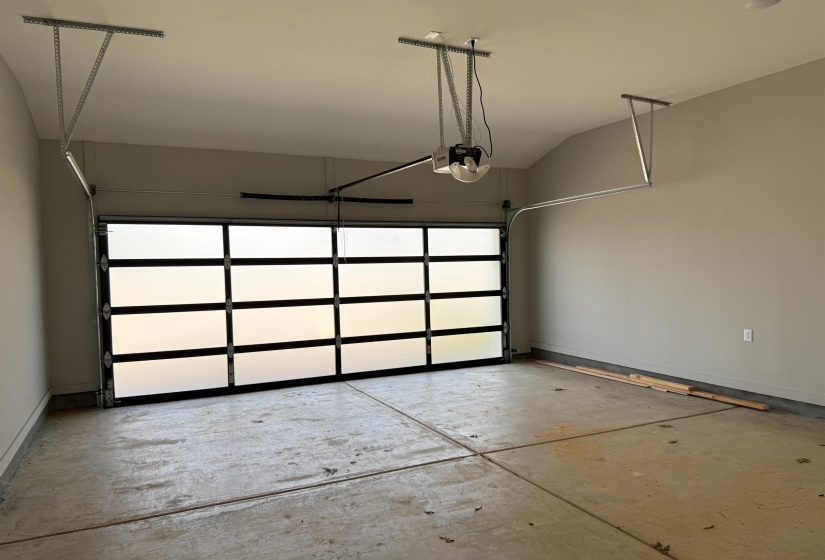 Garage featuring baseboards and a garage door opener
