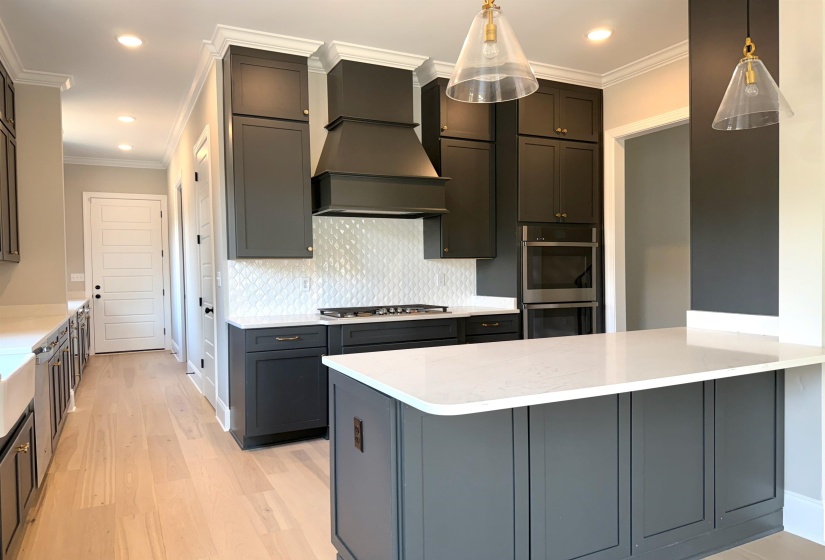Kitchen featuring ornamental molding, backsplash, light stone countertops, a peninsula, and stainless steel appliances