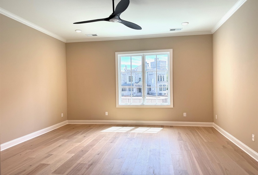 Bedroom featuring light wood-type flooring, crown molding, and ceiling fan