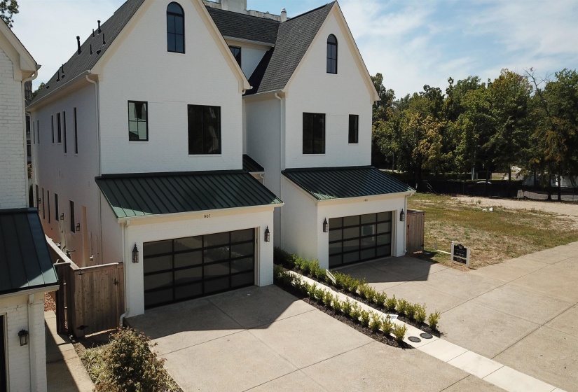 View of front of home featuring a garage, driveway, a metal roof, and a standing seam roof