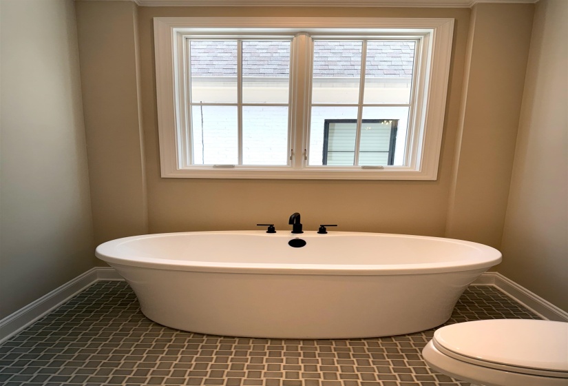 Bathroom with a freestanding tub, tile patterned flooring, and healthy amount of natural light