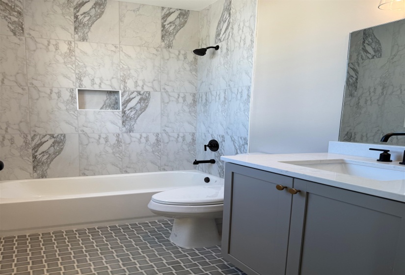 Full bathroom with bathtub / shower combination, vanity, and dark tile patterned floors