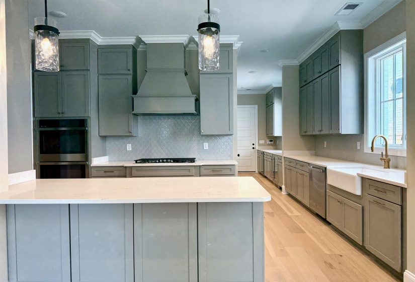 Kitchen featuring tasteful backsplash, stainless steel appliances, light wood-style flooring, ornamental molding, and light stone counters