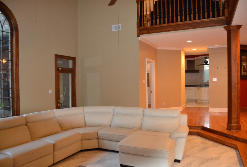 Living area with a ceiling fan, marble finish flooring, ornate columns, recessed lighting, and ornamental molding