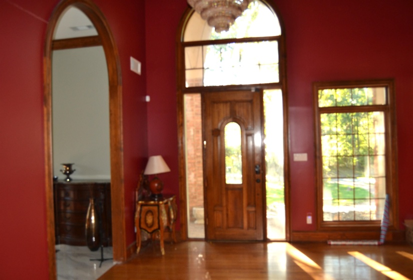 Foyer featuring wood finished floors and a chandelier