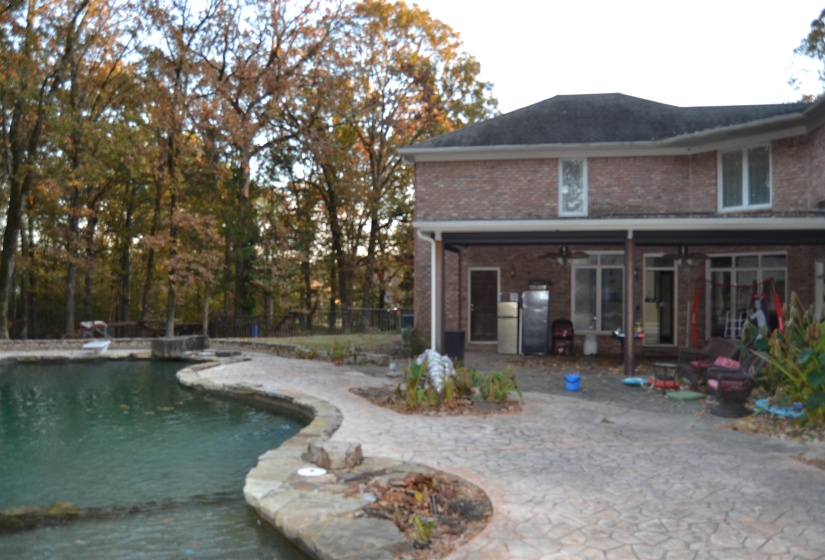 Back of property featuring a patio, a ceiling fan, brick siding, and an outdoor pool