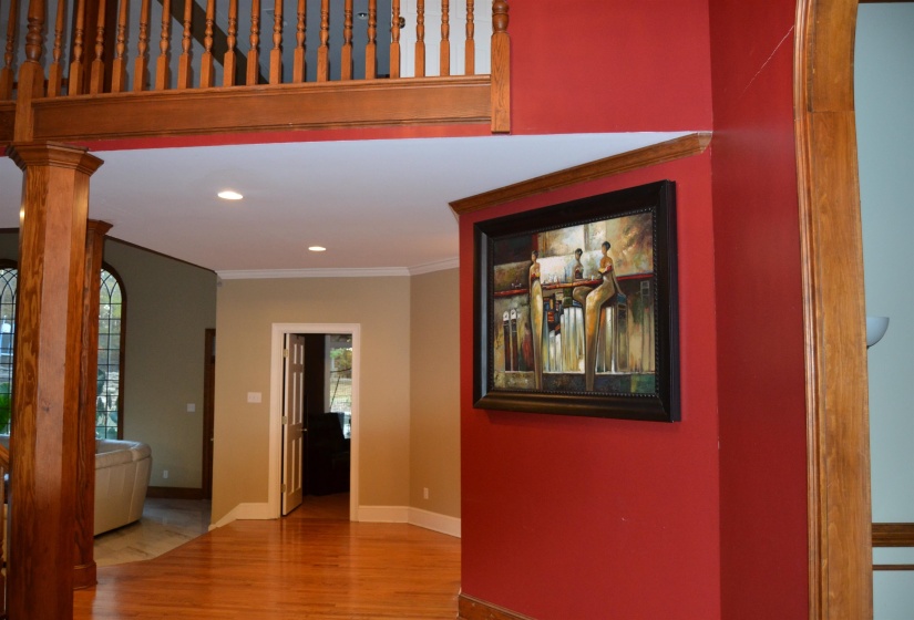 Hall with light wood finished floors, ornamental molding, and recessed lighting