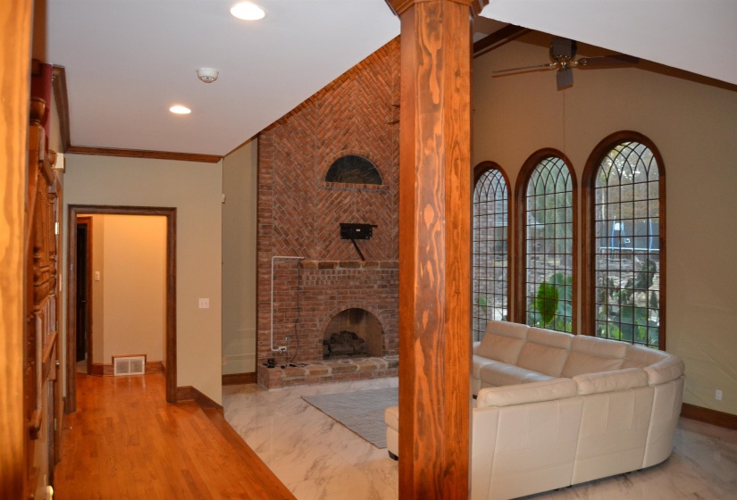 Unfurnished living room with ornamental molding, a fireplace, wood finished floors, a ceiling fan, and recessed lighting