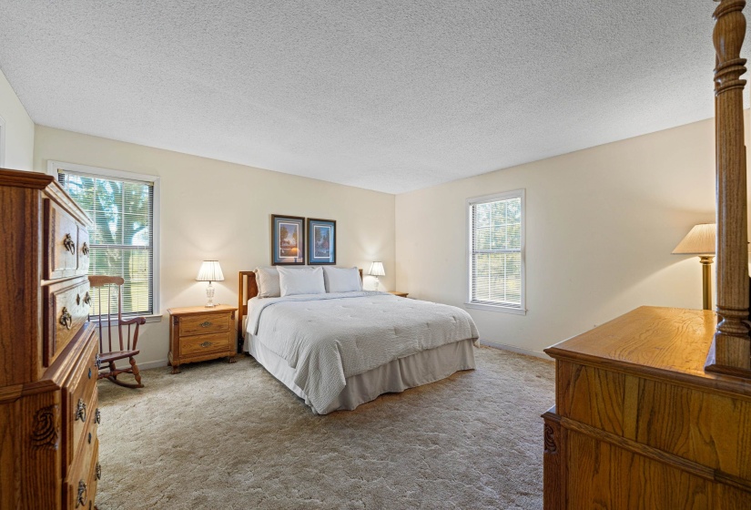 The primary suite offers abundant space and a seamless connection to its private en suite bathroom. Ideal for unwinding after a long day, this room combines comfort, functionality, and timeless appeal in one restful retreat.