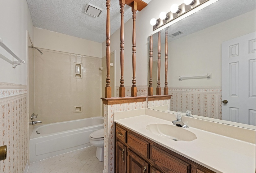 With tile floors and a generous single-sink vanity, this bathroom layout balances style and practicality, providing a comfortable space that makes daily routines a breeze.