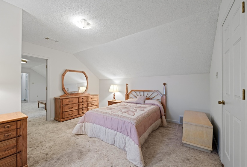 Generous in size, this upstairs bedroom features neutral walls and carpeting, making it a versatile space for sleeping, working, or relaxing. Its upstairs location adds privacy and separation from the hustle and bustle of the main living areas.