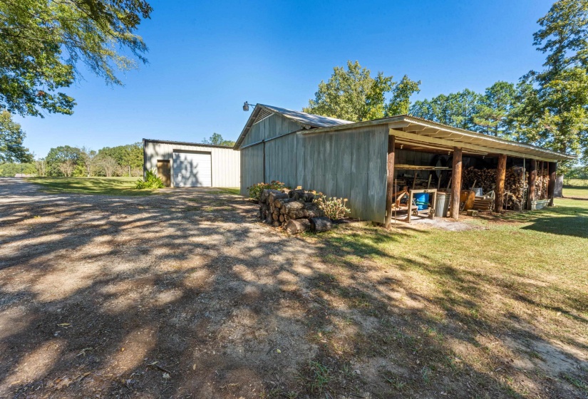 The large shop and smaller barn/shop with covered lean-to provide a variety of functional spaces for work and storage. This exterior perspective emphasizes the property’s flexibility, utility, and connection to the surrounding land.
