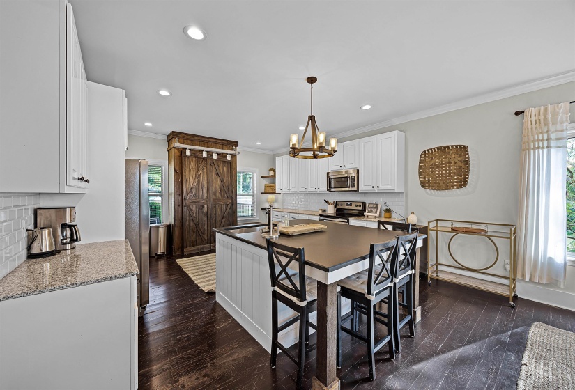 Kitchen featuring white cabinets, ornamental molding, backsplash, dark wood-style flooring, and healthy amount of natural light