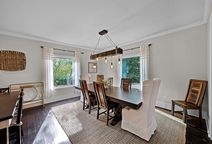Dining space featuring ornamental molding, dark wood-style floors, and plenty of natural light