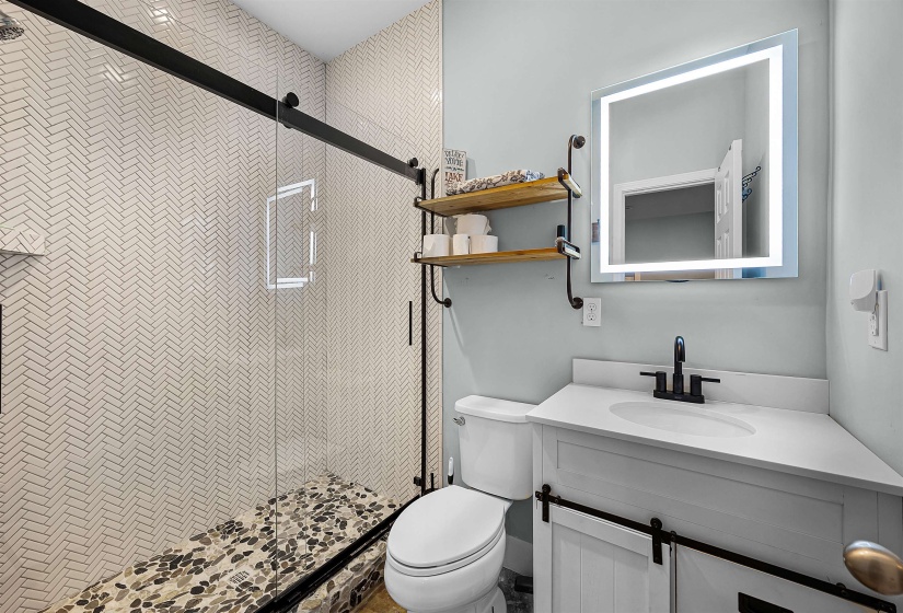 Full bath featuring a stall shower and vanity