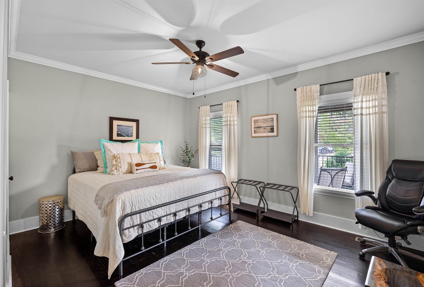 Bedroom with multiple windows, ornamental molding, dark wood-style flooring, and ceiling fan