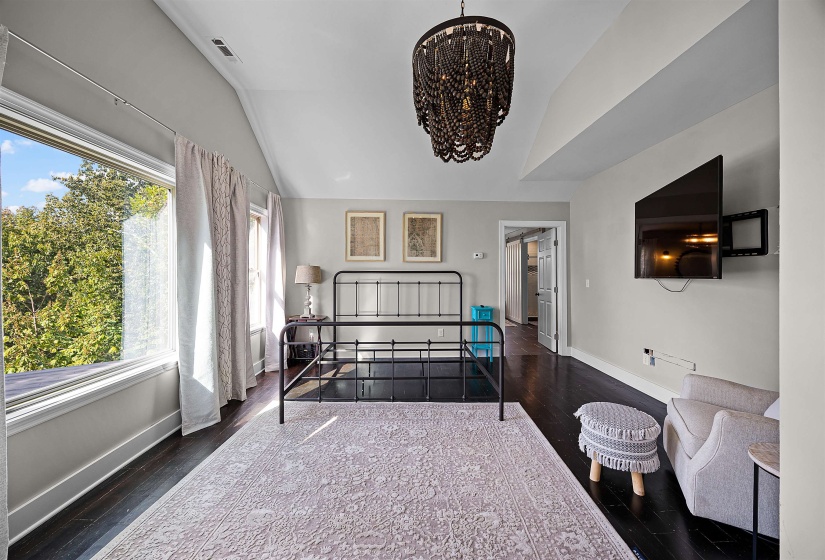 Bedroom featuring lofted ceiling, a chandelier, and dark wood-style floors