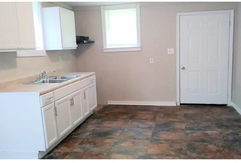 Kitchen featuring white cabinets, light countertops, and extractor fan