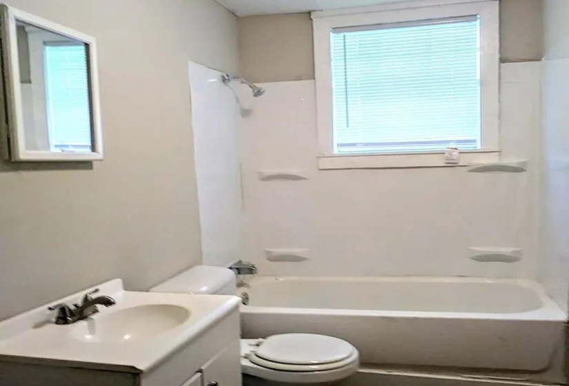 Bathroom with healthy amount of natural light, vanity, and tub / shower combination