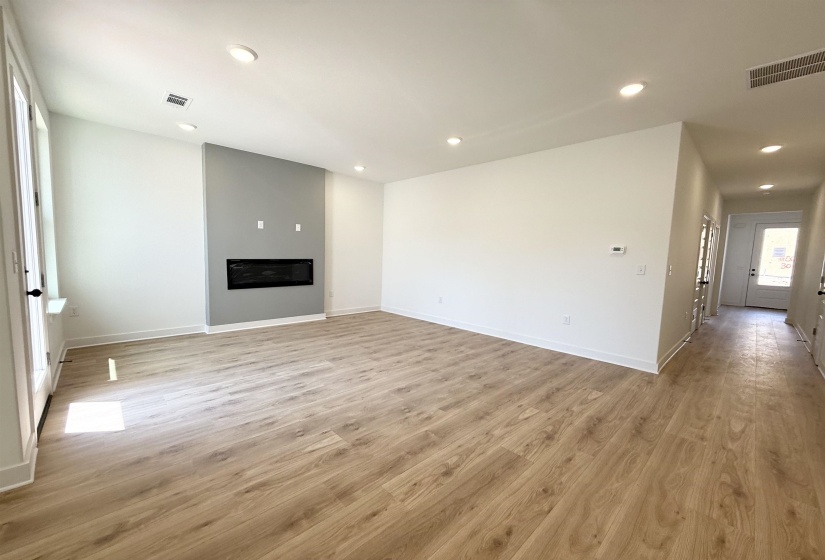 Unfurnished living room with light wood-type flooring, recessed lighting, and a glass covered fireplace