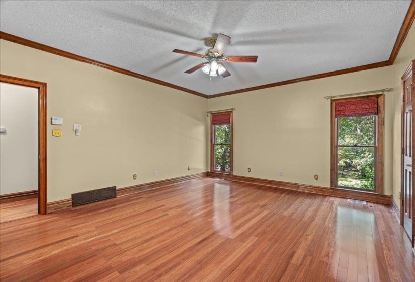 Spare room with crown molding, light wood-style flooring, a textured ceiling, and ceiling fan