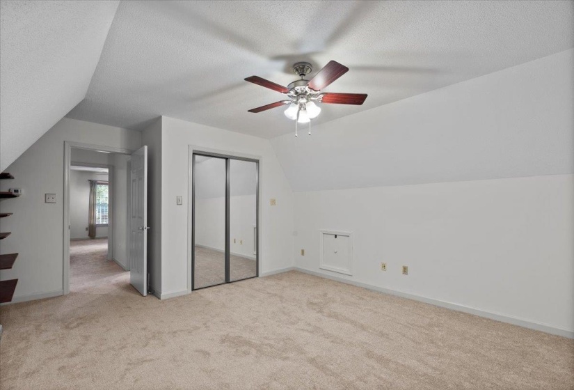 Bonus room featuring lofted ceiling, light colored carpet, a textured ceiling, and ceiling fan