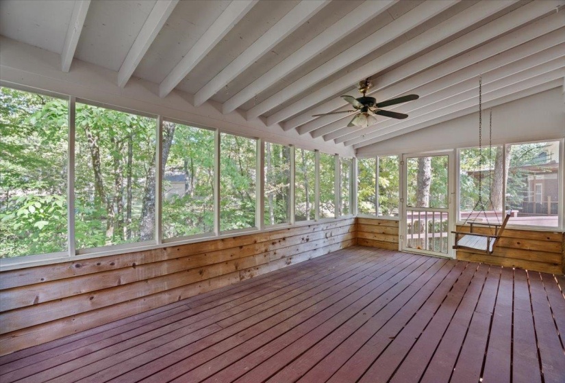 Unfurnished sunroom featuring a ceiling fan and a deck