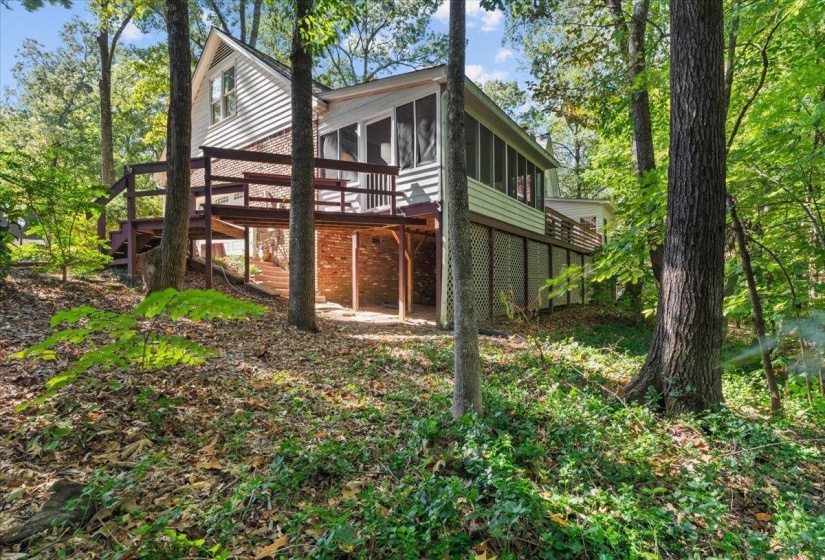 Rear view of house with a sunroom and a deck