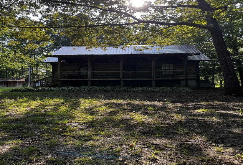 Back of property with a metal roof and view of wooded area