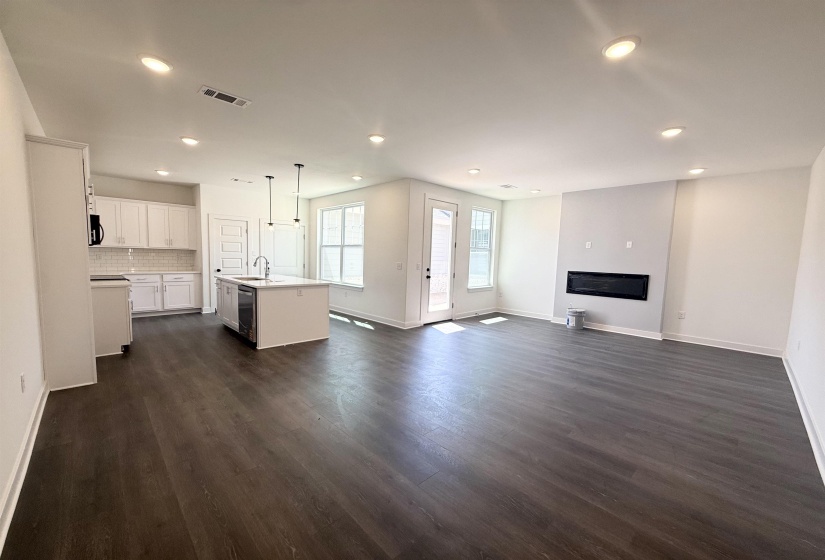 Unfurnished living room featuring dark wood-style flooring and recessed lighting