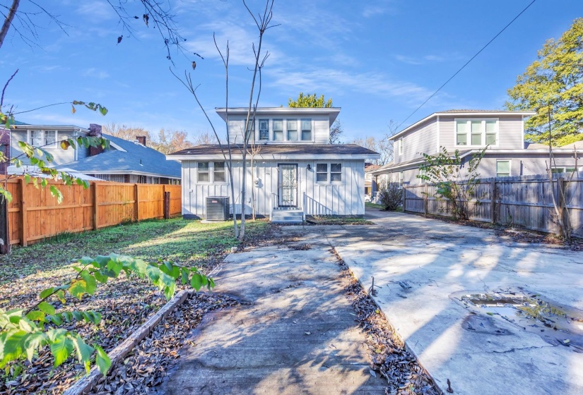 Rear view of property featuring board and batten siding and driveway